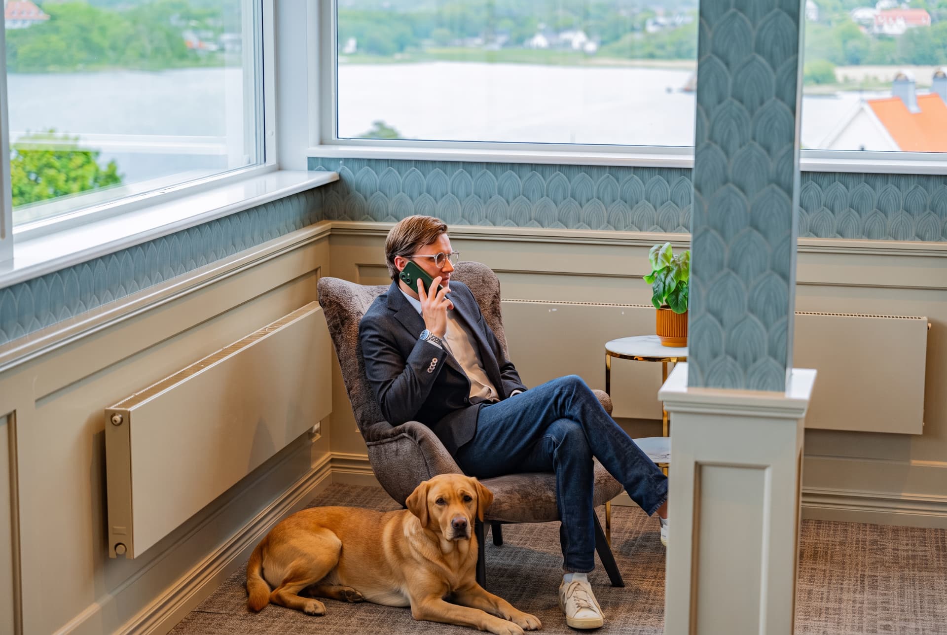 Konferensgäst med sin hund vid fönstret med havsutsikt